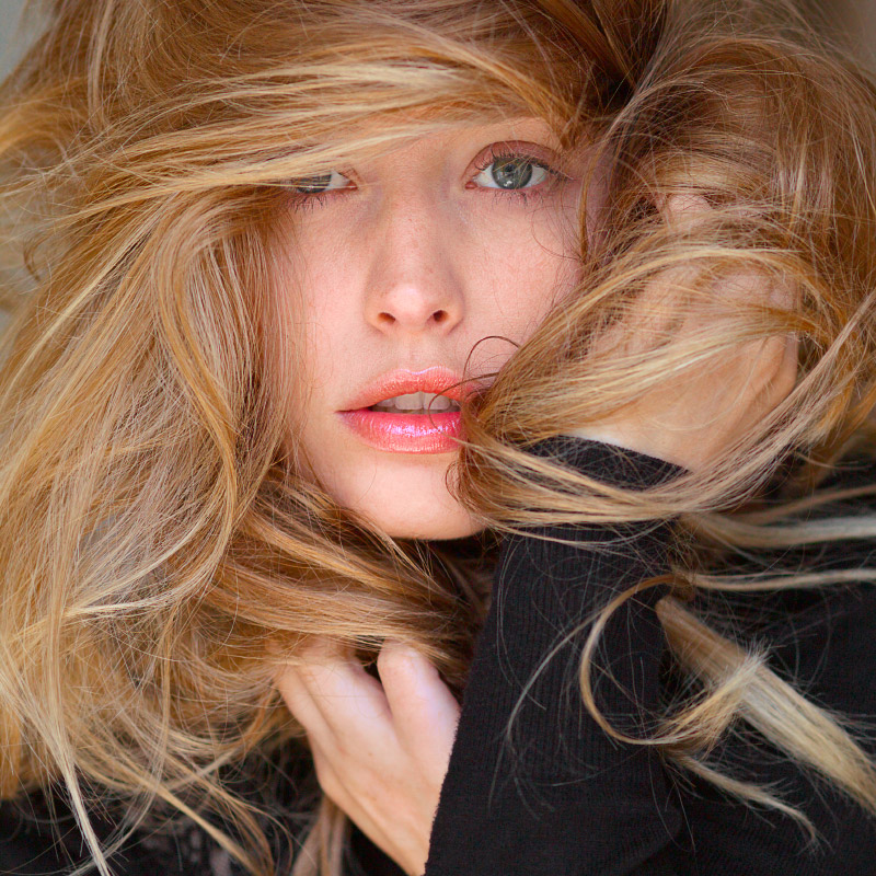 Blond woman hiding in her hair