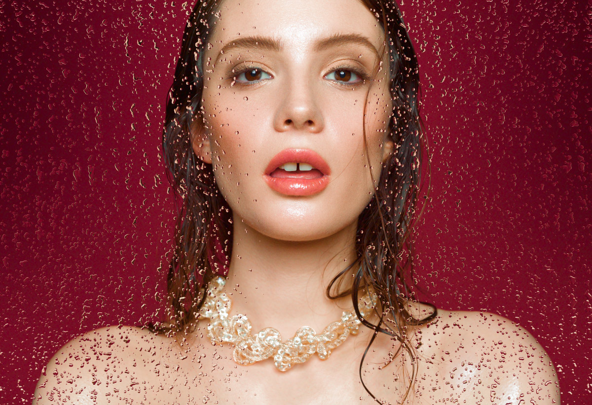 Beauty portrait of a young fashion model with water drops.